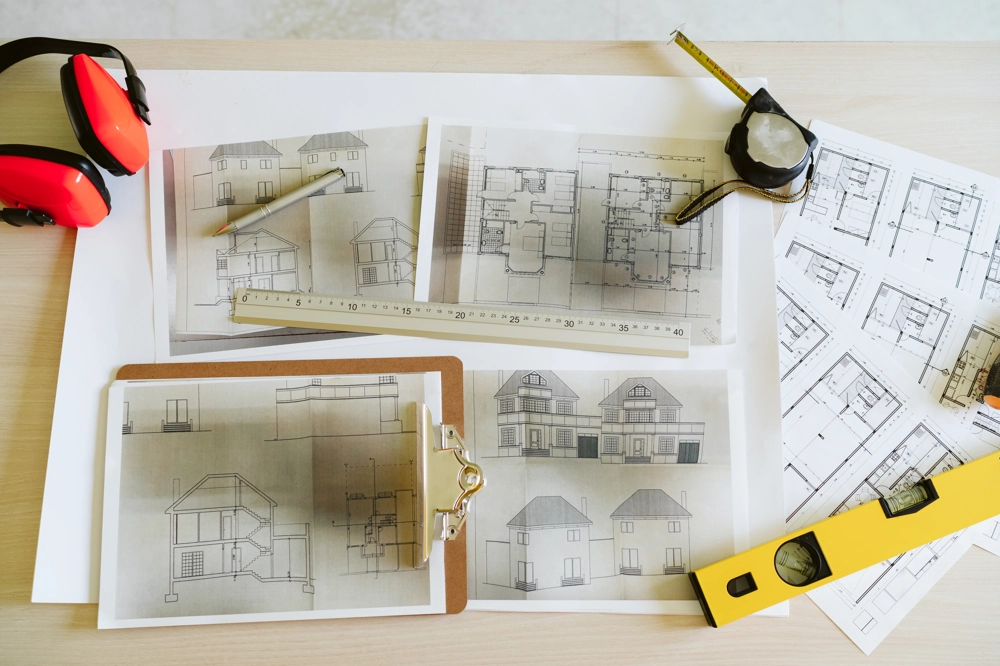Plany architektoniczne domu z linijką, miarką i poziomicą podczas adaptacji projektu